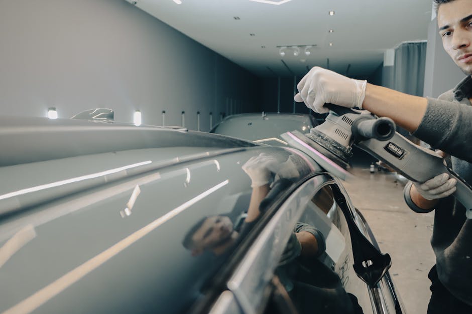 Professional auto detailer actively working on car exterior